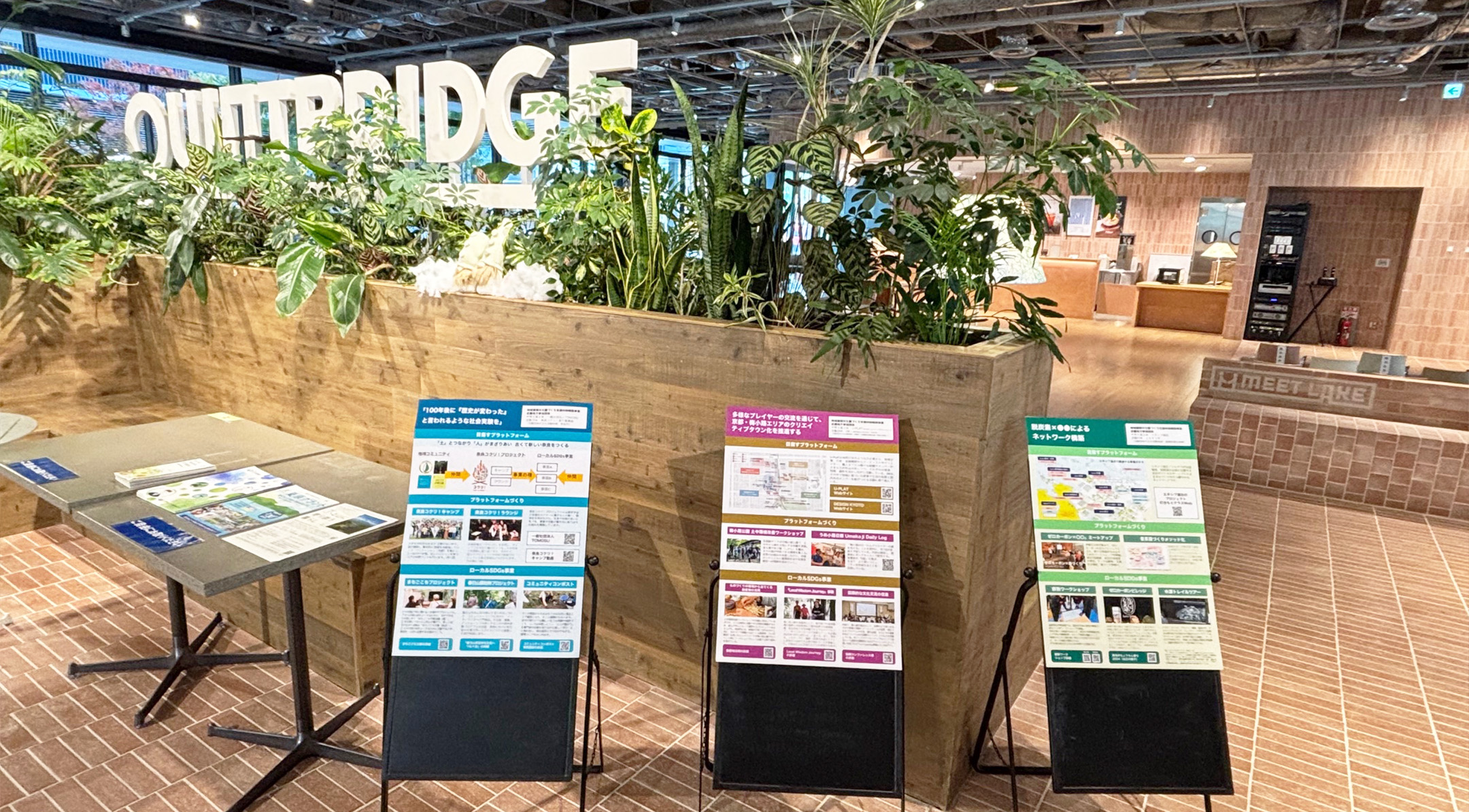 展示ブースの様子。壁面に地域循環共生圏の事例や政策を解説するパネルが多数掲示され、テーブルには配布資料が用意されている。対面や視覚情報を通じた情報発信の現場